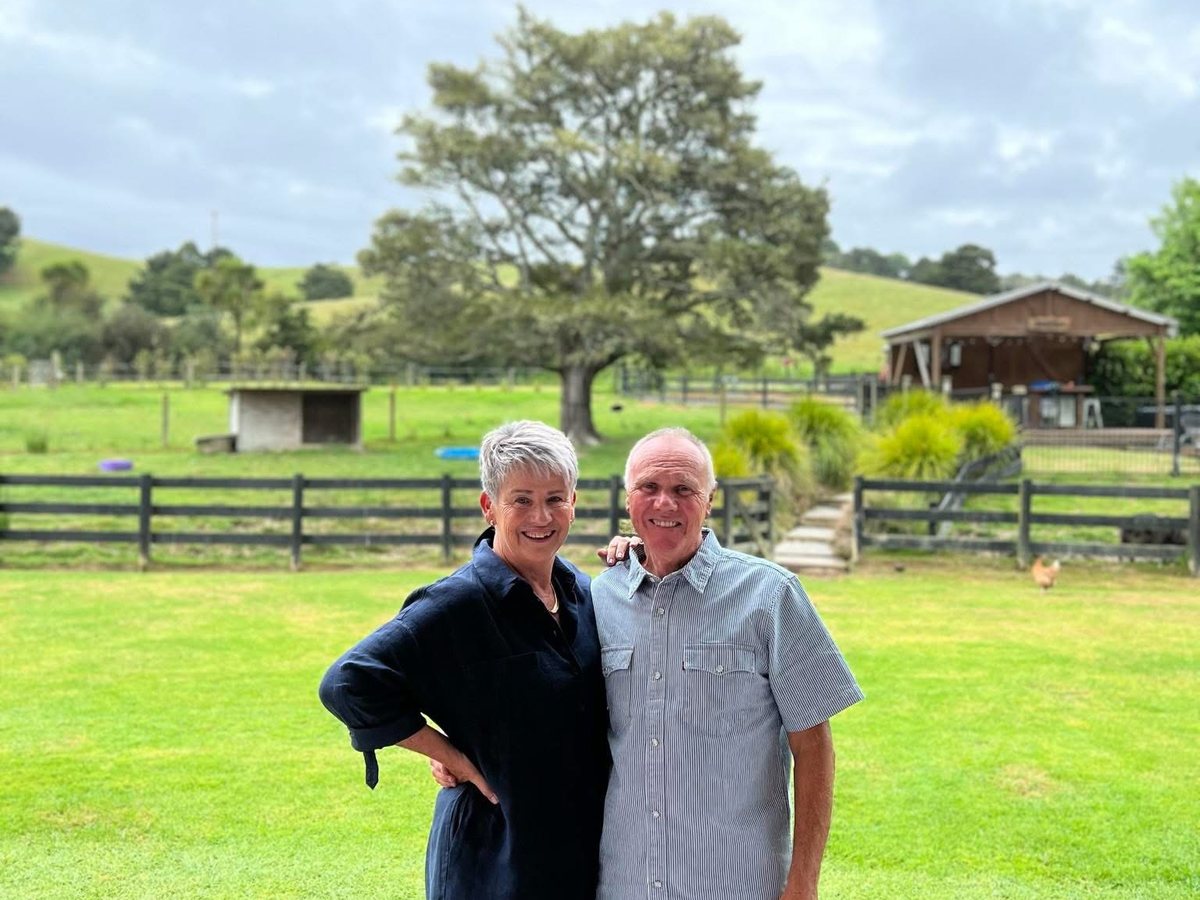 Jackie and John, the couple behind Finishing Touch Cleaners, smiling together outside their home
