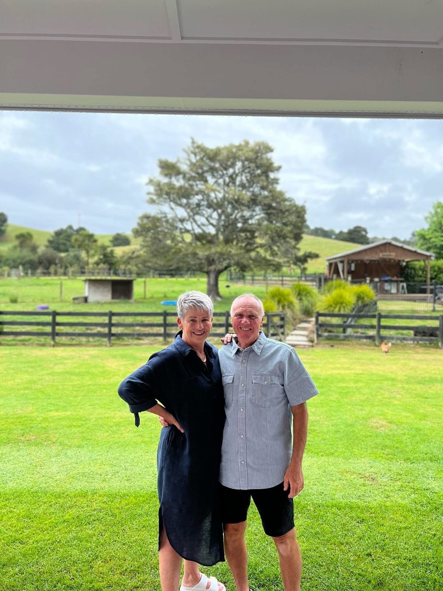Jackie and John, the husband-and-wife team behind Finishing Touch Cleaners, standing together on their lawn